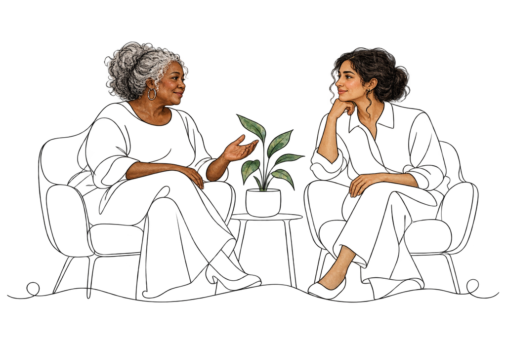 An older woman and a younger clinician in conversation beside a plant
