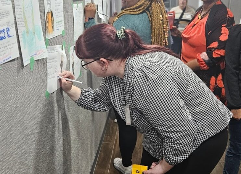 Mélanie writing on a workshop board